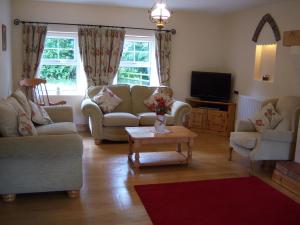 a living room with two couches and a tv at Annagh Cottage in Bellaghy