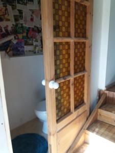 a bathroom with a toilet and a wooden cabinet at Augšistaba Beči in Vecumnieki