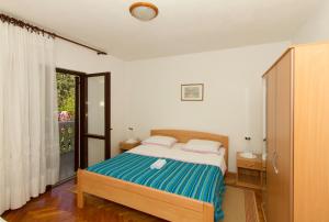 a bedroom with a bed and a large window at Apartments Joso in Zadar