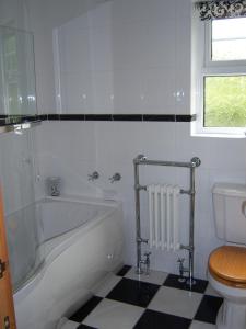 a white bathroom with a tub and a toilet at Annagh Cottage in Bellaghy