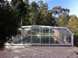 a glass house with a swimming pool inside at Quinta do Castro Wood House in Marco de Canavezes
