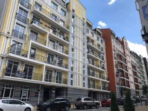 un gran edificio con coches estacionados frente a él en MODERN LUXURY Apartment in the heart of Kiev en Kiev