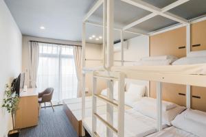 東京的住宿－PLAYSIS Asakusa，宿舍间配有双层床和书桌。