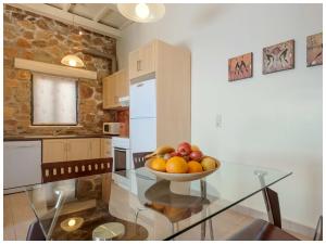a kitchen with a glass table with a bowl of fruit at Meliti Sunset View & Private Pool Villa 20 min from Elafonissi in Livadia
