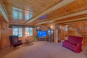 Sala de estar con 2 sillas rojas y TV en Grandma's Cabin Yellowstone Vacation Home en Island Park