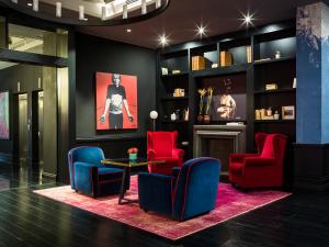 une chambre avec des chaises rouges, une table et une étagère dans l'établissement Palazzo Cornalia, à Milan