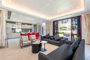 a living room with couches and a table and a kitchen at HaitangBay Loosen Coast Resort Villas in Sanya