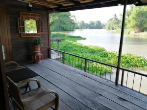Ban Tha PongRustic​ Charm​ Suphan​的享有河景的门廊上设有屏风