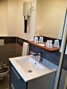 baño con lavabo y teléfono en Hôtel Trianon, en Juan-les-Pins