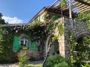 a house with flowers on the side of it at Lake house Puro in Dodo&scaron;i
