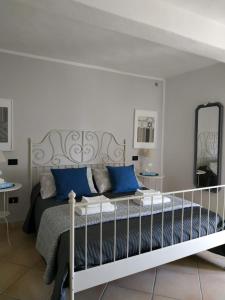 a bedroom with a bed with blue pillows and a mirror at Villa Venino in Moneglia