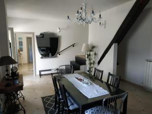 a dining room with a table with chairs and a chandelier at Villa Venino in Moneglia