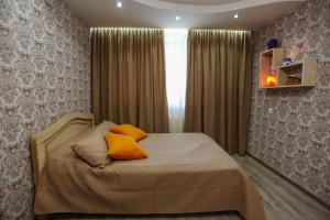 a bedroom with a bed with two orange pillows on it at N&N House in Tbilisi City