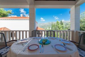 a table with plates and silverware on a porch at Astra Villas in Zaton
