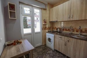 eine Küche mit einer Spüle und einer Waschmaschine in der Unterkunft N&N House in Tbilisi City