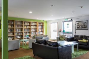 a library with couches and chairs and bookshelves at Bonington Student Village (Campus Accommodation) in Sutton Bonington