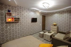 sala de estar con sofá y TV en la pared en N&N House en Tiflis