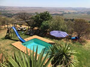 una pequeña piscina con sombrilla y sombrilla en Mount Nebo Hillside Reserve, en Muldersdrift