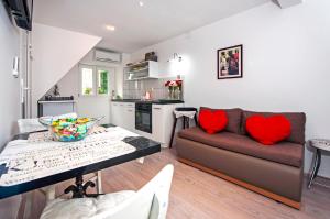 salon z kanapą i stołem z czerwonymi poduszkami w obiekcie Apartman Delfin w Rovinj
