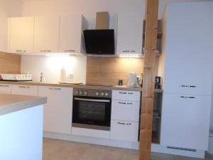 a kitchen with white cabinets and a stove at Ferienwohnung am Kirchberg in Jois