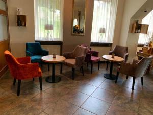 a waiting room with tables and chairs and windows at Hotel Angelo in Saarbrücken