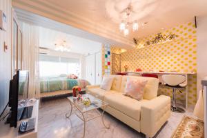 Papillon Paradis Higashi-Shinjuku في طوكيو: غرفة معيشة مع أريكة وغرفة نوم