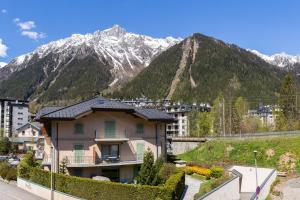 ein Haus in einer Stadt mit Bergen im Hintergrund in der Unterkunft Appartement Lyret II B22 - Happy Rentals in Chamonix-Mont-Blanc