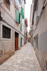pusta ulica w alejce pomiędzy dwoma budynkami w obiekcie Apartman Delfin w Rovinj