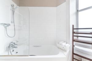 La salle de bains blanche est pourvue d'une douche et d'une baignoire. dans l'établissement Spacious & Unique city central 1 bed with WiFi, à Édimbourg 23 autres photos