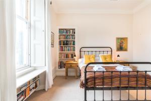 a bedroom with a bed and a book shelf at Spacious & Unique city central 1 bed with WiFi in Edinburgh