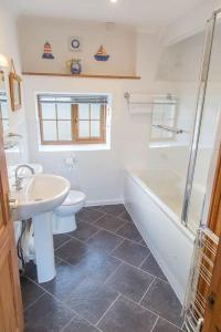 y baño con lavabo, aseo y ducha. en Elidir Cottage, en Llanfairpwllgwyngyll
