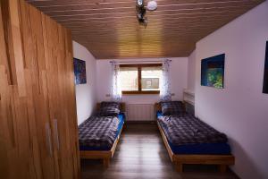 two beds in a small room with a window at Ferienwohnung Sulzberg in Alpirsbach