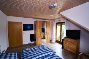 1 dormitorio con 1 cama y TV de pantalla plana en Ferienwohnung Sulzberg, en Alpirsbach