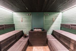 a room with three wooden benches in a room at Grand Hotel Liberty in Riva del Garda