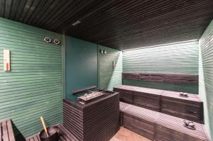 a sauna with two benches in a green wall at Grand Hotel Liberty in Riva del Garda