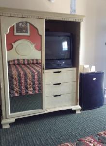 um quarto com uma cama e uma televisão num armário em New Orleans Inn em Nova Orleães