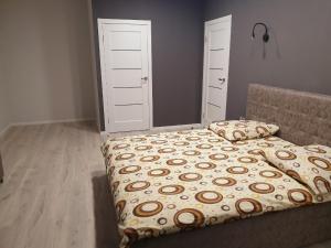 um quarto com uma cama com um edredão e almofadas em Apartments Yes em Uzhhorod