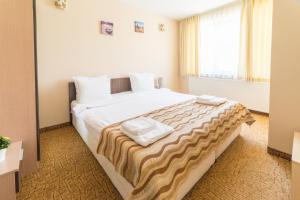 ein Schlafzimmer mit einem großen Bett mit zwei Handtüchern darauf in der Unterkunft Ring Hotel in Blagoewgrad