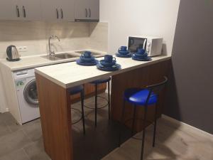 cocina con fregadero y encimera con taburetes azules en Apartments Yes, en Uzhhorod