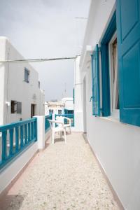 a balcony with a blue door and a table at Florance Apartments & Rooms in Mikonos