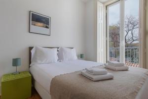 um quarto com uma cama com duas toalhas em LovelyStay - Sunny Santa Catarina I em Lisboa