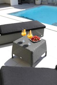 a table with two wine glasses and a bowl of fruit at Luxury Villa Nada with Pool in Petrcane