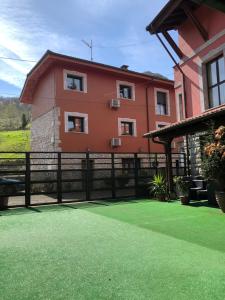 una casa con una valla y un patio verde en Apartamento El Estanque - HA Peña Santa, en Benia
