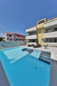 a swimming pool in front of a building at Luxury Villa Nada with Pool in Petrcane