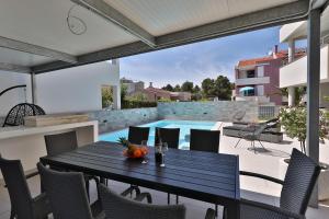 a dining table and chairs on a patio with a pool at Luxury Villa Nada with Pool in Petrcane