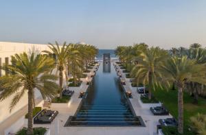 a beach filled with lots of palm trees at The Chedi Muscat in Muscat