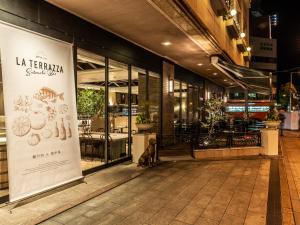 a dog sitting in front of a store front at HOTEL MYSTAYS Matsuyama in Matsuyama