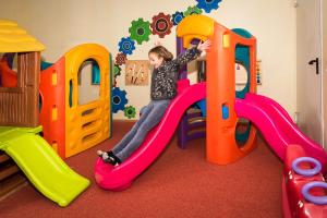 a young girl playing on a slide in a play room at Herzlfassl in Kolsassberg