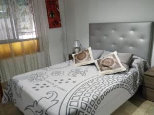 a bedroom with a bed with two pillows on it at Habitaciones privadas Alicante centro in Alicante