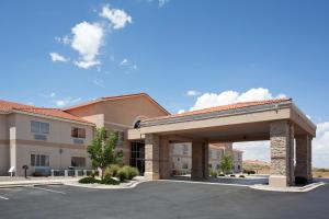 a building with a parking lot in front of it at Baymont by Wyndham Belen NM in Belen